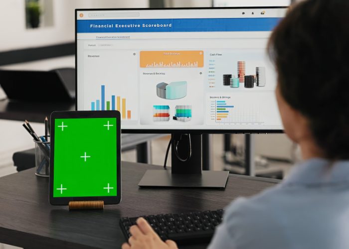 Manager watches tablet with greenscreen while she solves business operations in office, looking at device running blank mockup display. Specialist looks at chromakey software. Handheld shot.